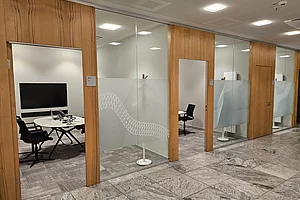 Modern gestalteter Kundenservicebereich mit Sitzgruppen und diskreten Beraterzimmern Innenarchitektur Augsburg,Neu gestaltetes Beraterzimmer mit Sichtschutz, akustischer Abschirmung und hochwertiger Ausstattung für diskrete Finanzberatung.